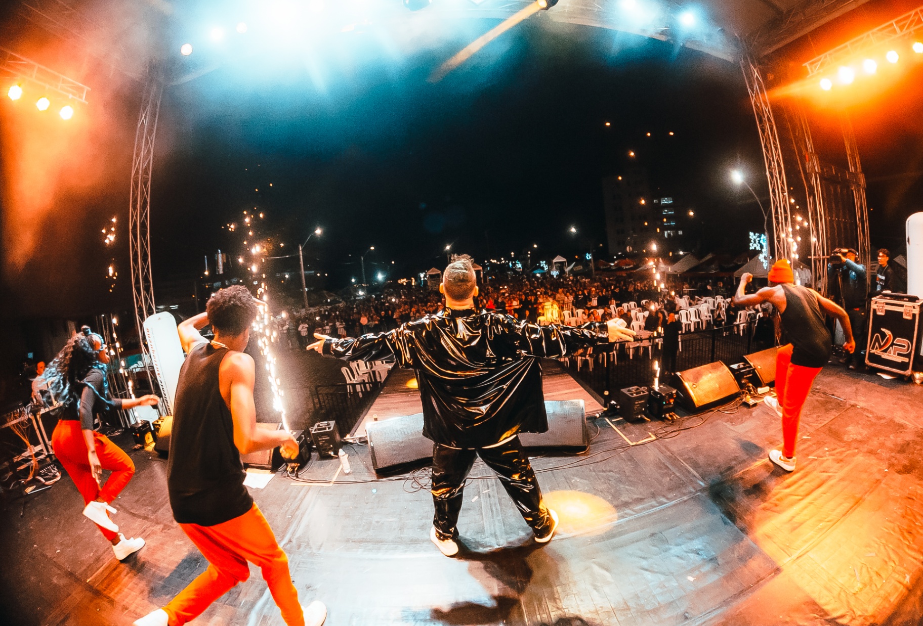 Heider Gonzalez de espaldas con chaqueta negra frente al público